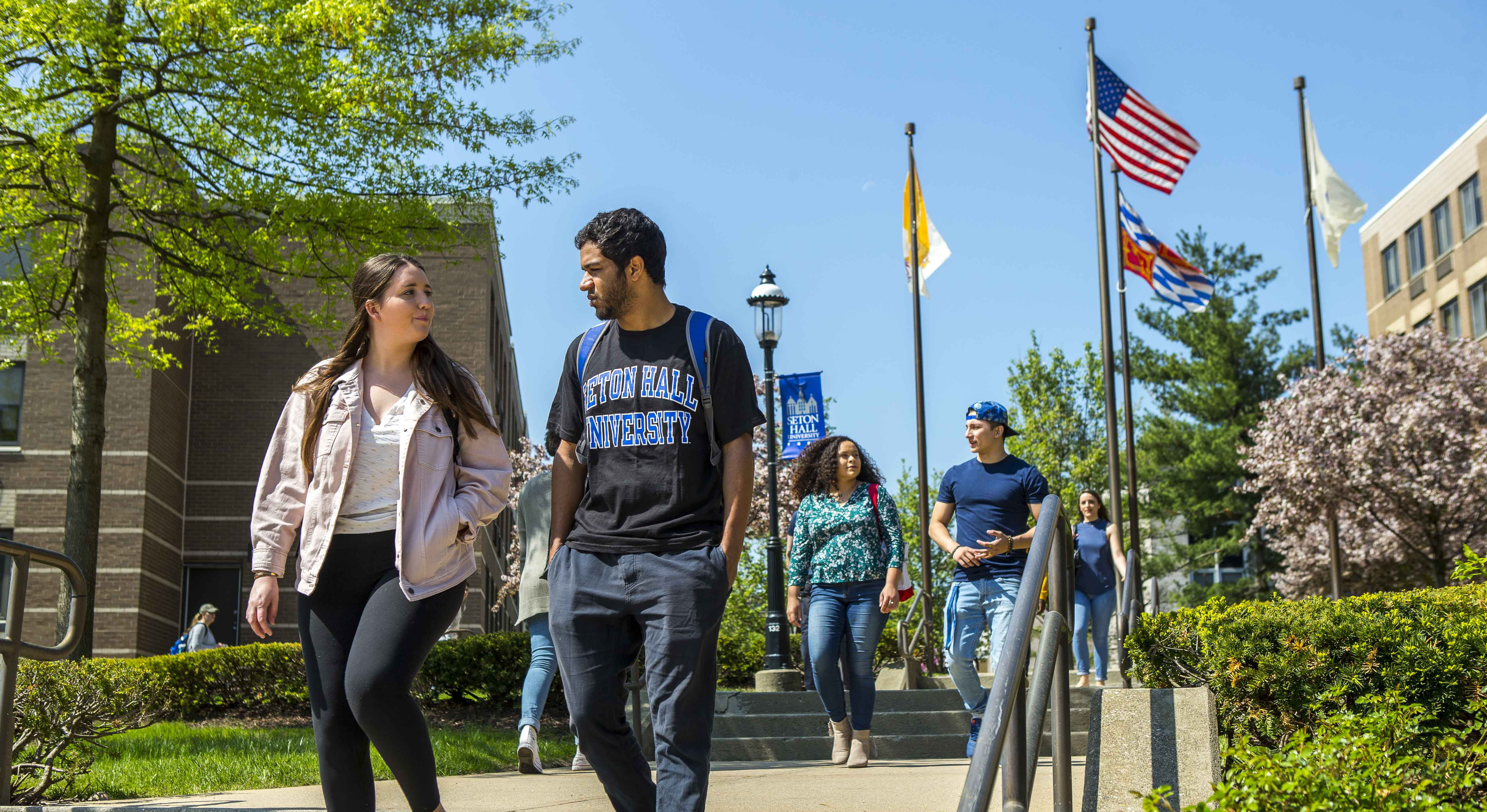 Students walking with flags behind them