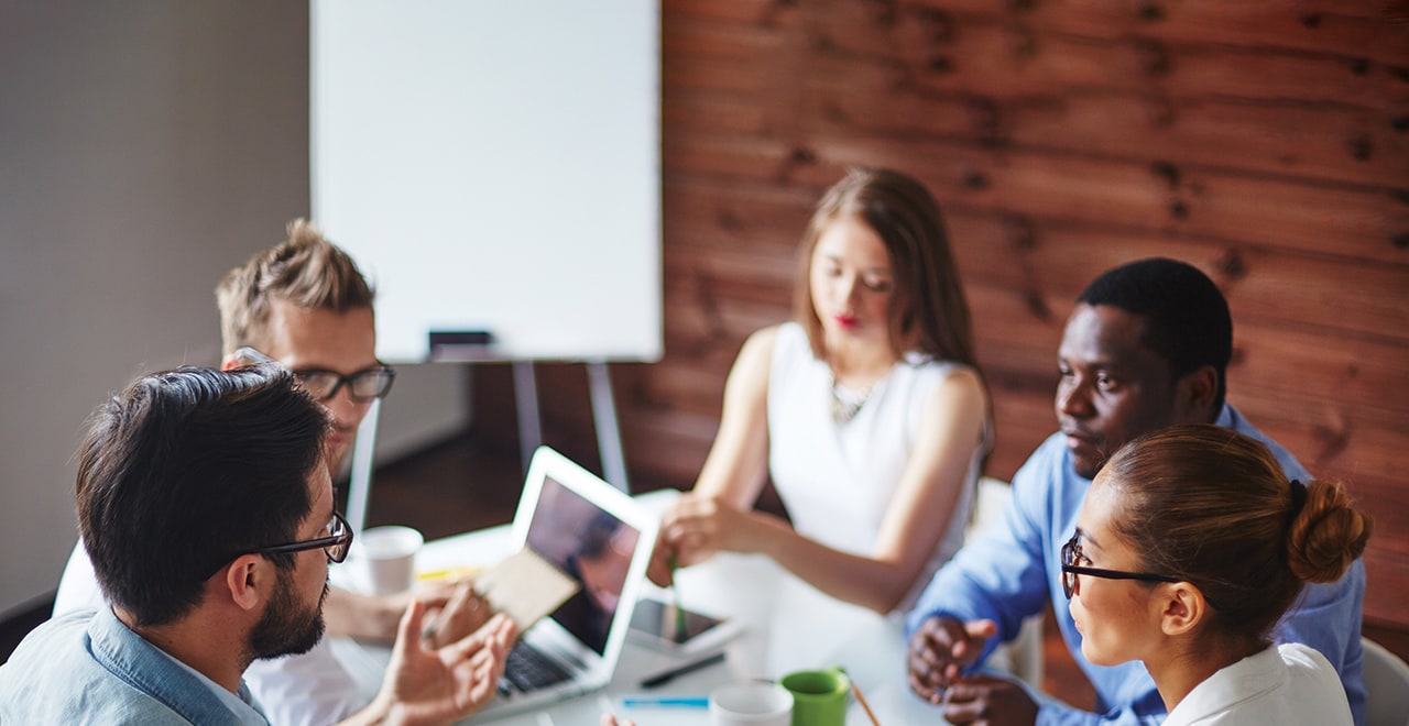 A photo of people sitting around a conference table having a discussion.