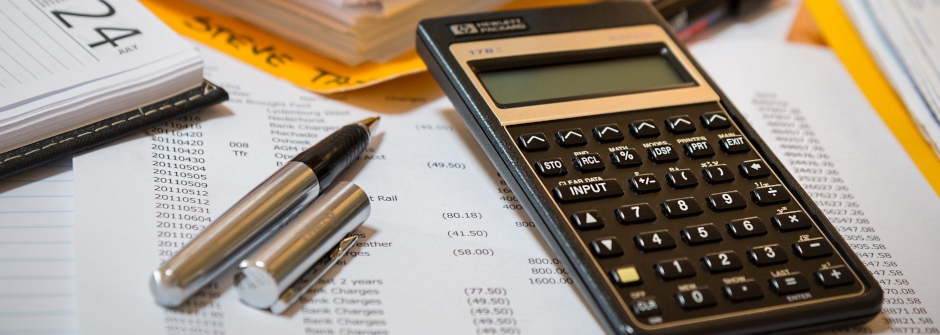 A photo of a calculator, pencil, and paper