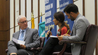 Nadia Murad holding microphone and speaking on stage.