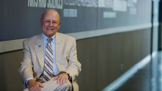 Nicolas Scalera sitting in a chair in front of a board. 