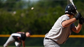 Image of a pitcher at the mound and a batter about to swing. 