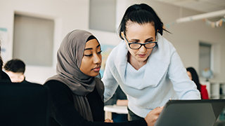 A student and a faculty member looking over a computer screen