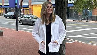 Alyssa deangelis posing next to a tree.