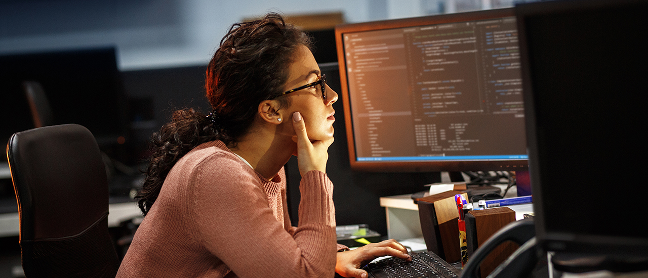 A person looking at data on a computer monitor.