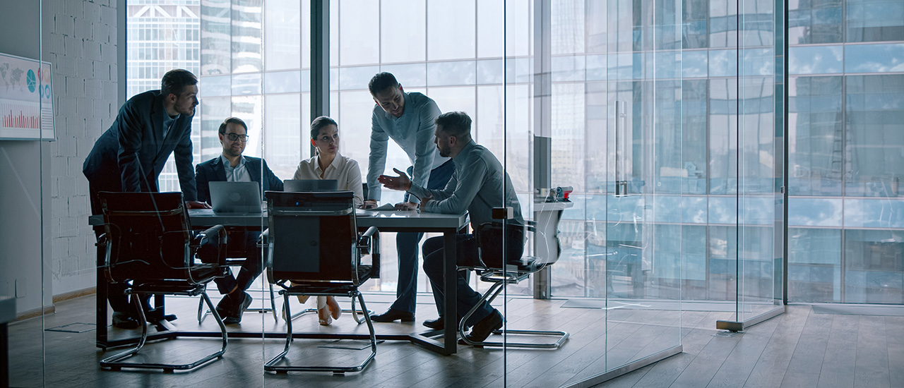People sitting around a conference table in a business setting.
