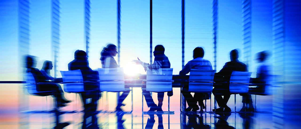 People sitting around a conference table in an office building.