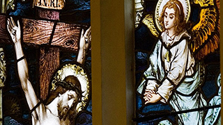 Christ and an angel stained glass Stained glass window of Christ on the cross and an angel visiting his side