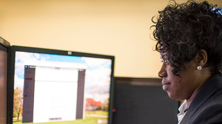 A photo of a woman staring at a computer screen