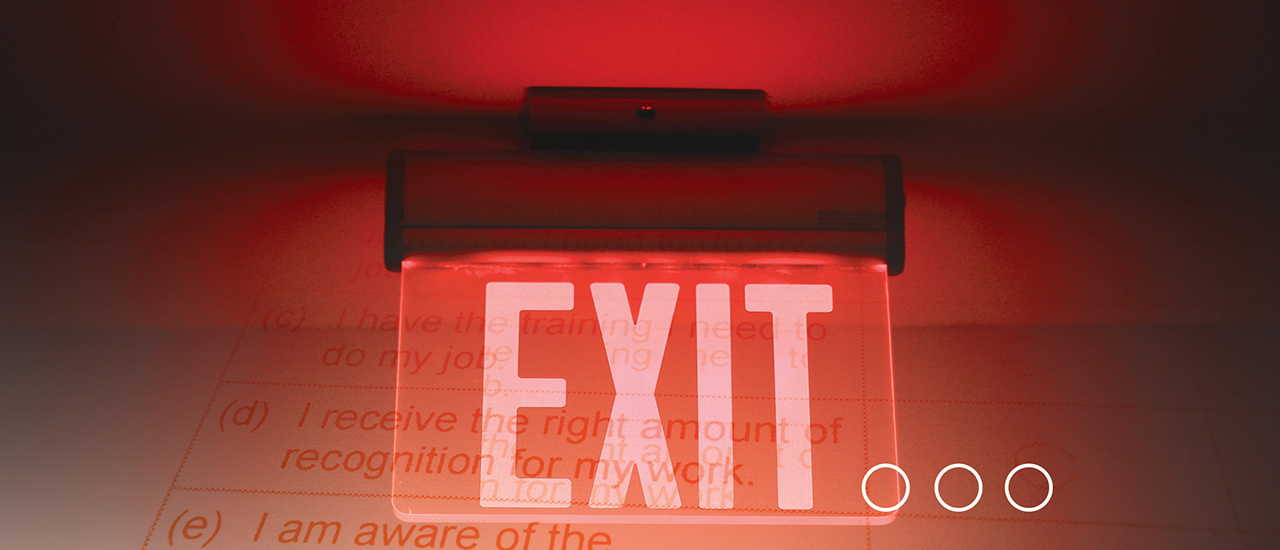 An exit sign that is lit up in red lighting.