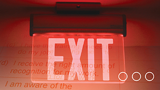 An exit sign that is lit up in red.