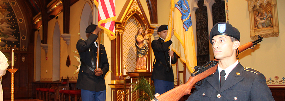 Image of an ROTC cadet getting sworn in outside with an American flag in the background. 