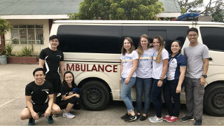 Student from the School of Health and Medical Sciences in front of an ambulance. 