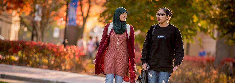 Students walking and talking on campus. 