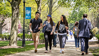 A photo of students walking and talking on campus.